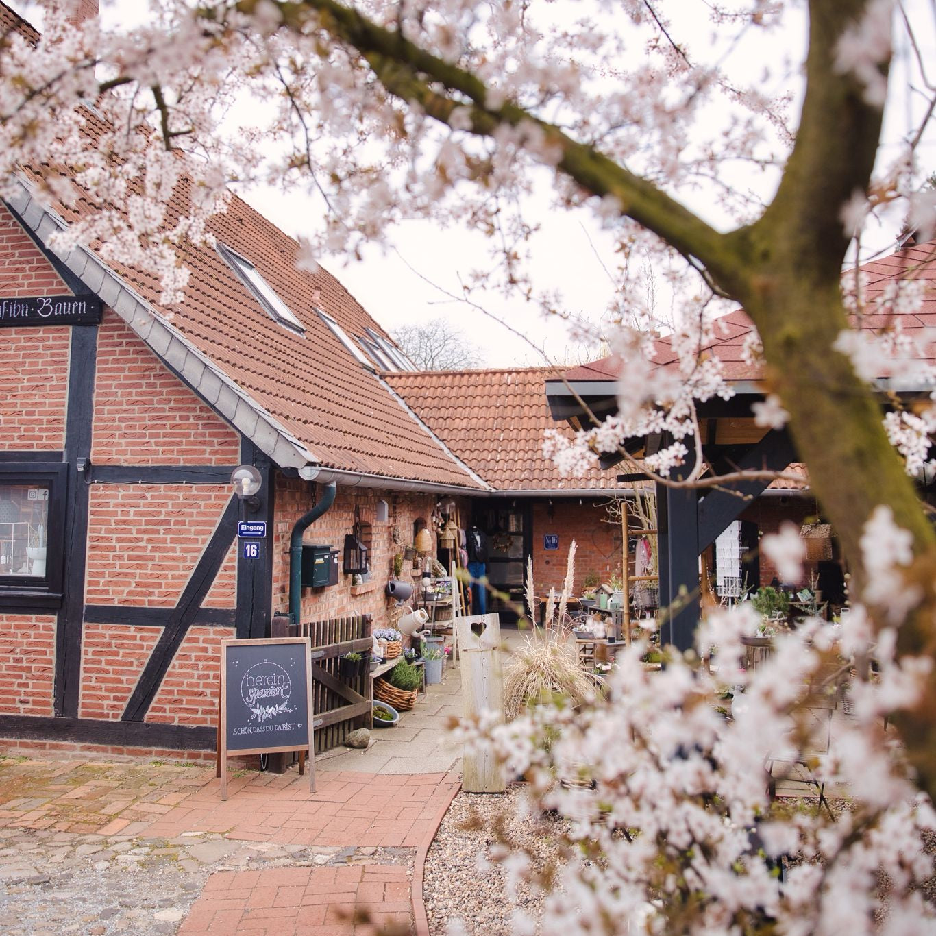 Fachwerkhaus mit roten Klinkern und Tafel vor der Tür.