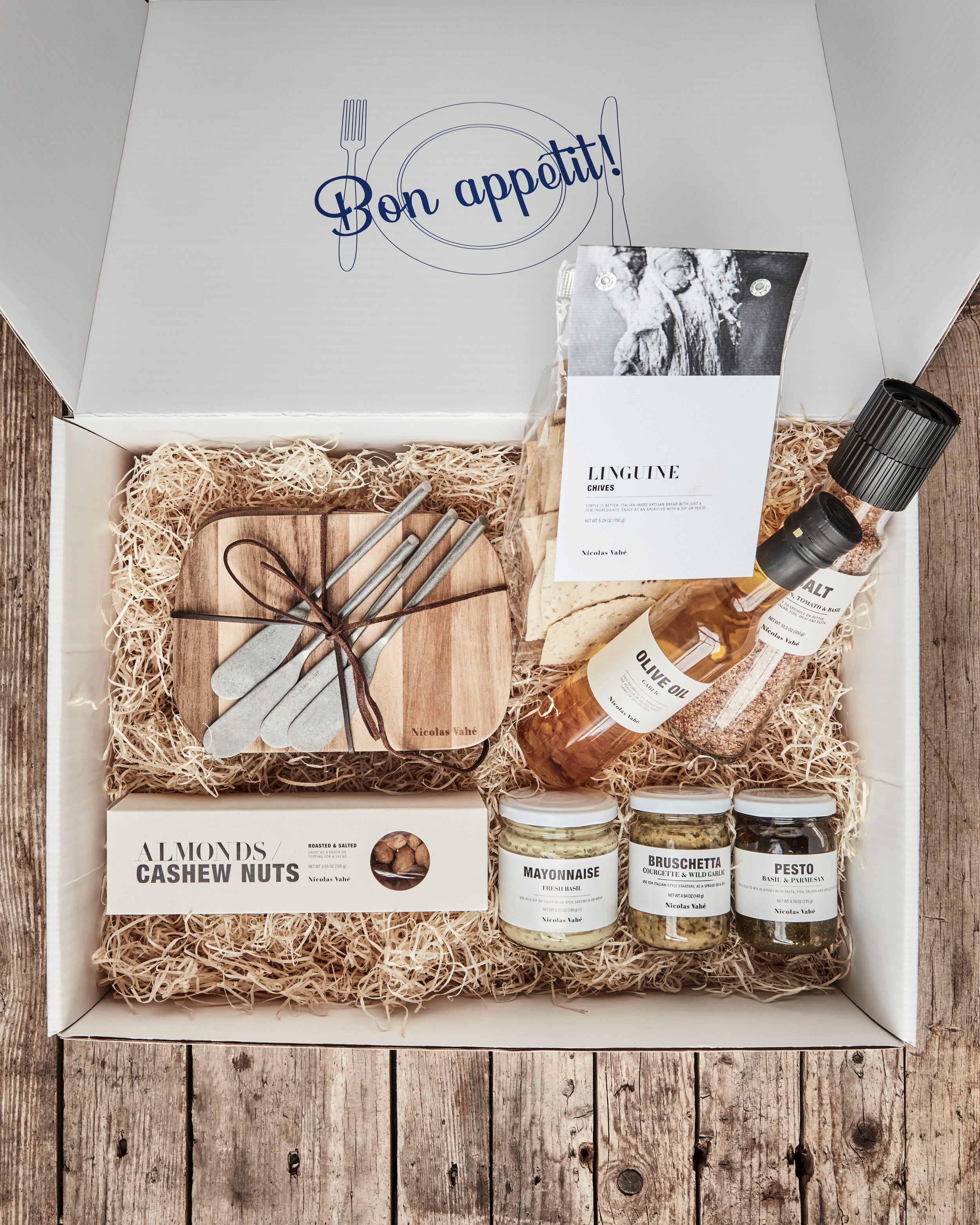 Geschenkkiste mit Holzwolle und Feinkost.