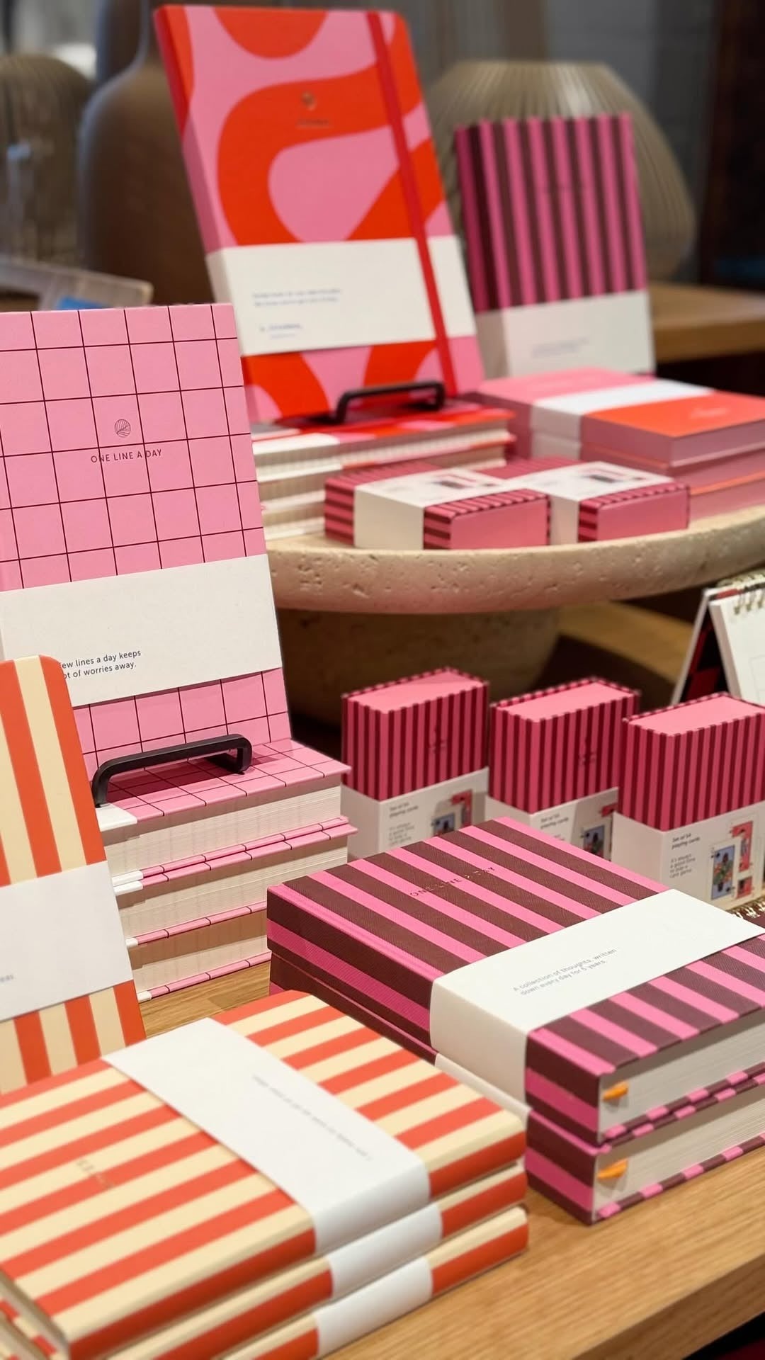 Bunte Notizbücher in pink, rot und weiß gestreift