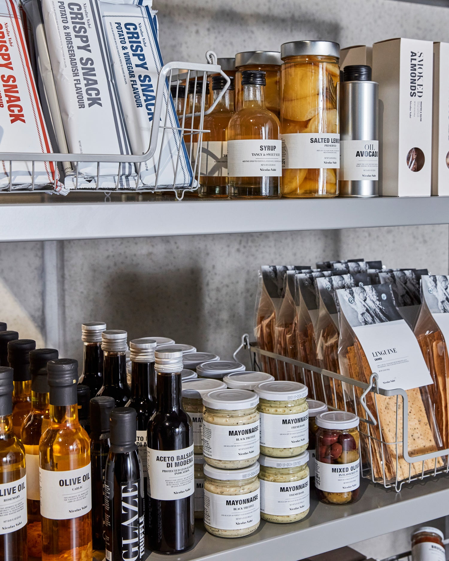 Ein Metallregal gefüllt mit Feinkost mit schlichten Etiketten.